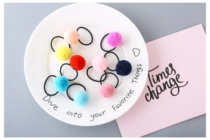 Detailed view of 9pcs colorful macaron pom pom hair ties displayed in a ceramic tray