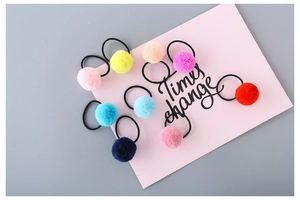 Detailed close-up of colorful plush pom pom hair ties set in assorted candy colors