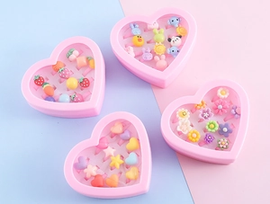 Detailed view of four heart-shaped boxes filled with colorful cartoon rings for children