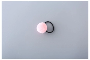 Close-up of a soft pink pom-pom hair tie with a black high-elasticity rubber band