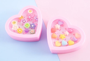 Detail view of heart-shaped gift boxes with various colorful cartoon resin rings for kids