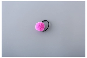 Close-up of bright pink faux fur pompom hair tie with a black elastic rubber band