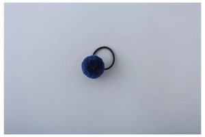 Detail of dark blue plush pom-pom hair tie with high-elastic black rubber band