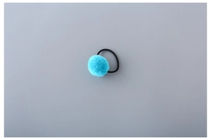 Detailed view of elastic hair tie featuring a soft sky blue faux fur pom pom decoration