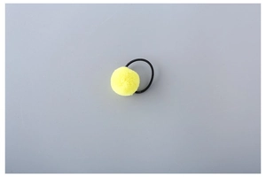 Detailed view of a bright yellow plush pom pom hair tie with a black elastic band
