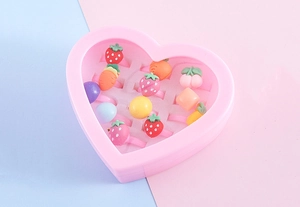 Pink heart-shaped gift box filled with 12 colorful cartoon fruit and animal kid rings