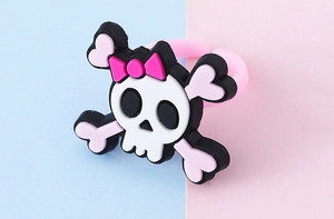 Dettaglio dell'anello in PVC per bambini con teschio e fiocco rosa per Halloween