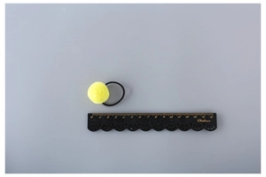 Detailed size measurement of a yellow pom pom hair tie with a 15cm wooden ruler