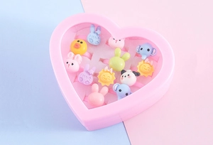 Close-up of heart-shaped box with 12 colorful resin cartoon rings for children