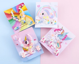 Set di gioielli colorati per bambini con temi di unicorni e arcobaleni su cartoncini