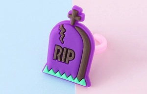 Vista macro dell'anello di Halloween a forma di lapide viola in PVC morbido con RIP
