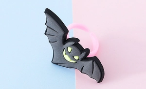 Primo piano dell'anello a pipistrello di Halloween con occhi gialli e fascia rosa
