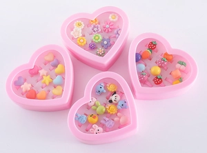 Detailed view of children's cartoon rings in pink heart-shaped boxes with resin designs
