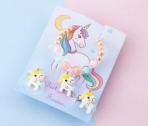 Dettaglio di set gioielli per bambini con ciondoli unicorno e bracciale perline macaron
