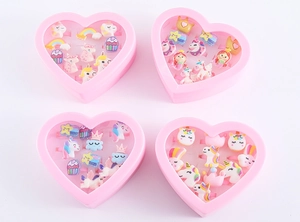 Roze hartvormige doosjes met cartoonringen voor kinderen zoals eenhoorns en regenbogen