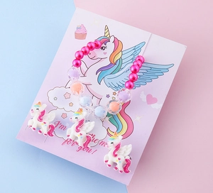 Dettaglio del braccialetto di perle arcobaleno con ciondoli unicorno su carta