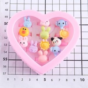Set of 12 colorful cartoon resin rings for kids in a pink heart-shaped display box