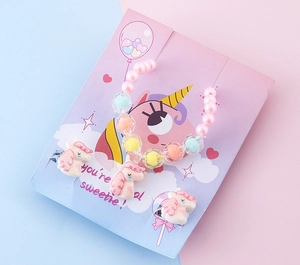 Dettaglio del braccialetto di perline rosa con unicorno e orecchini a clip per bimbe