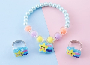 Dettaglio del bracciale di perle con ciondolo a stella e anelli regolabili coordinati