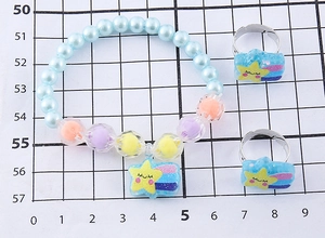 Dettaglio di un set di bracciale con perline e anelli per bambini con ciondoli a stella su scala