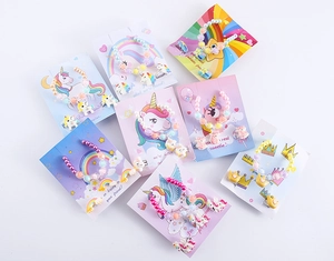 Dettaglio di braccialetti con perline colorate in resina e set di anelli con unicorno