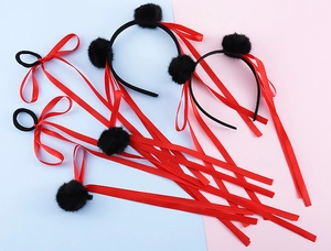 Dettaglio di nastri di seta rossi e cerchietti con pompon neri per stile cosplay cinese