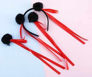 Set dettagliato di cerchietto e fermagli con palline di pelo nere e lunghi nastri rossi