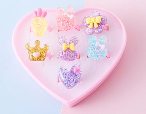 Set dettagliato di 7 anelli in resina glitterata per bambini in scatola a cuore
