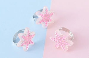 Gros plan de trois bagues flocon de neige en résine réglables pour enfants avec paillettes