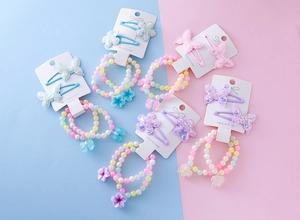 Détail de bracelets en perles macaron et barrettes à paillettes pour fillettes