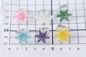 Détail de bagues flocon de neige en résine colorée avec anneaux réglables en métal fin