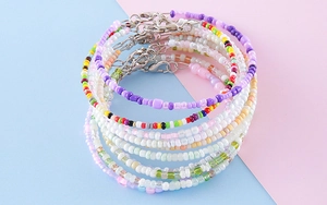 Détail de bracelets multicouches en perles colorées avec fermoirs mousquetons en métal