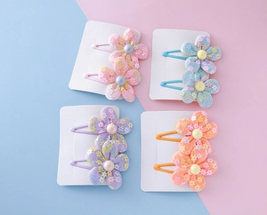 Detailed view of floral fabric hair clips for kids in various pastel colors on a card
