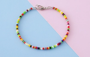 Détail d'un bracelet de perles colorées bohème avec un fermoir mousqueton en métal argenté