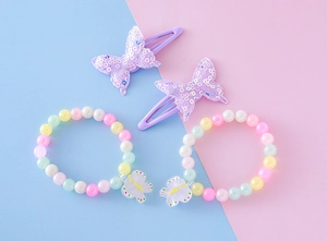 Gros plan de bracelets de perles macaron colorées et de barrettes à nœuds à paillettes