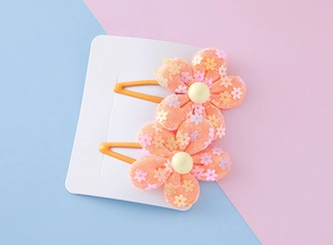 Close-up of pink mesh flower hair clips with sequins and pearls for little girls
