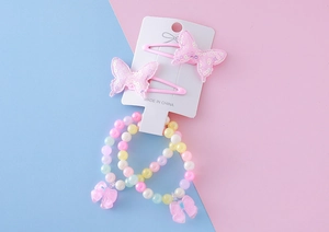 Détail des barrettes à paillettes roses et des bracelets en perles macaron pour filles