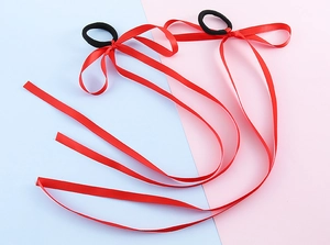 Dettaglio di elastici per capelli rossi con lunghi nastri di raso per acconciature
