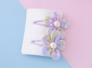Detail of sweet purple mesh flower hair clips with colorful sequins and pearls