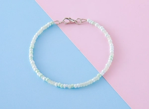 Gros plan sur un bracelet de perles multicouches avec perles vertes et fermoir mousqueton