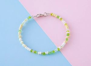 Détail de breloque en perles colorées avec perles vertes, jaunes, blanches et fermoir argent