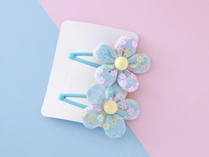 Detail view of sweet blue mesh flower hair clips with sequins for girls on display card