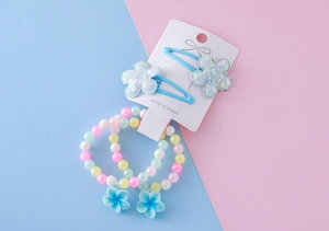 Détail de bracelets en perles colorées avec pendentifs fleurs et barrettes à paillettes