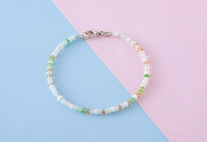 Gros plan d'un bracelet en perles de rocaille colorées avec fermoir mousqueton argenté