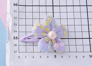 Detail of purple mesh flower hair clip with pearl center and silver metal alligator base