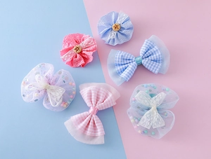 Détail de nœuds en maille pastel et barrettes à fleurs en dentelle pour filles en lot de 6