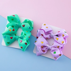 Sparkly heart patterned grosgrain bow hair clips in mint green and lavender purple