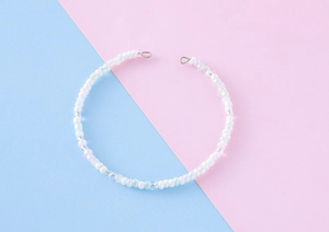 Detail of handmade colorful bead chain with iridescent white seed beads and silver rings