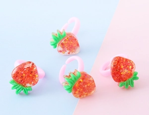 Vista dettagliata di quattro anelli fragola in resina rossa con glitter e fascia rosa