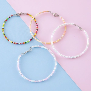 Ensemble de bracelets en perles colorées avec fermoir mousqueton sur fond pastel